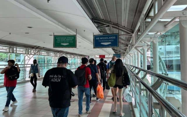 Travelers Crossing The Overhead Bridge Towards Johor Bahru CIQ, In The Direction Of Singapore Woodlands Checkpoint