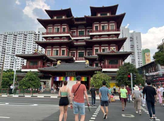 The iconic Buddha Tooth Relic Temple in Singapore, with its traditional Chinese architecture with ornate red and white tiered roofs and golden details.