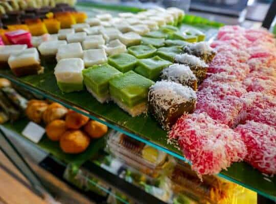 Traditional Nyonya kueh desserts displayed at a Singapore food stall, showcasing local flavours experienced during 24 Hours In Singapore.